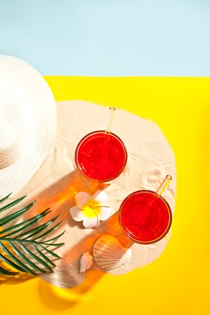 Coquetel de bebida refrescante de verão na praia. Areia, conchas e plumeria frangipani.