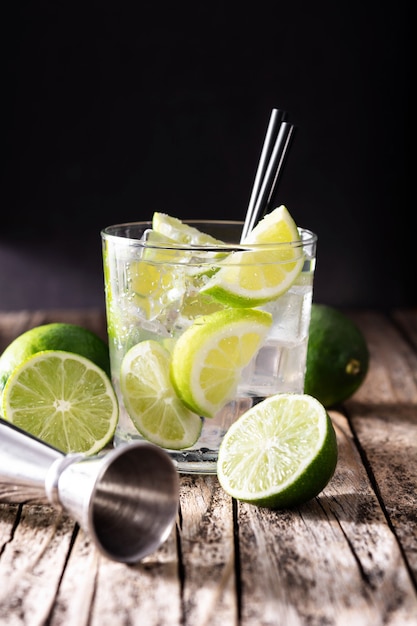 Coquetel de caipiroska com limão na mesa de madeira