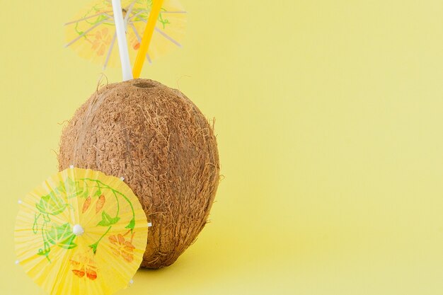 Foto coquetel de coco fresco com canudos em fundo amarelo, copie o espaço.