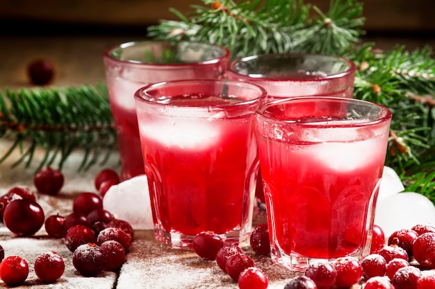 Coquetel de cranberry de natal com gelo decorado com ramos de abeto e foco seletivo de neve