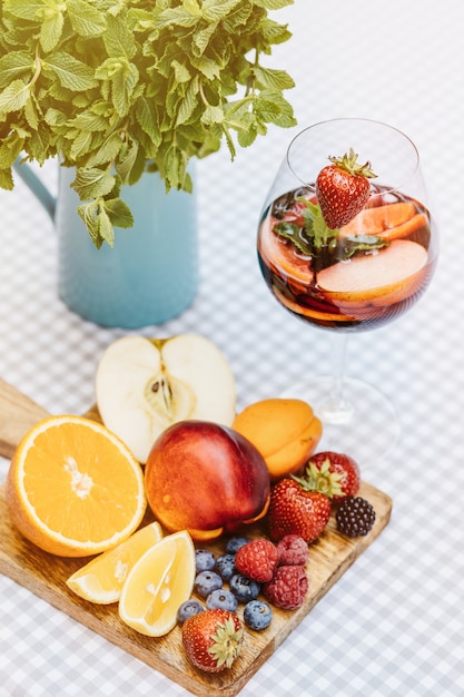 Coquetel de frutas na mesa de madeira branca com bagas e folhas de hortelã