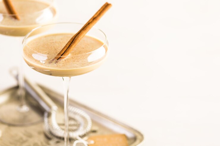 Foto coquetel de gemada natalina com rum escuro e leite decorado com noz-moscada.
