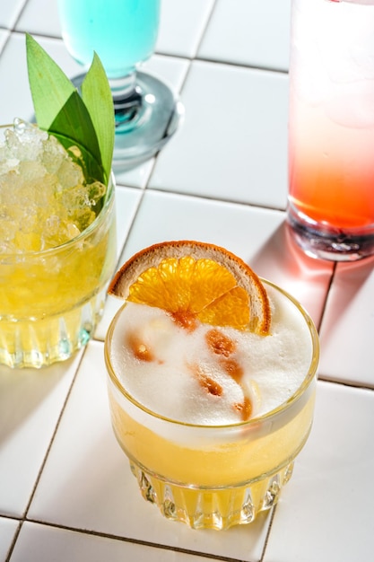 Foto coquetel de laranja alcoólico fechado em uma mesa de azulejos brancos