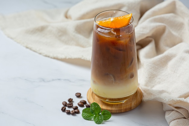 Coquetel de laranja e café na superfície branca.