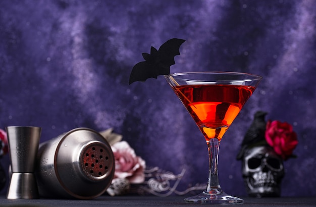 Coquetel de martini de Halloween em fundo roxo