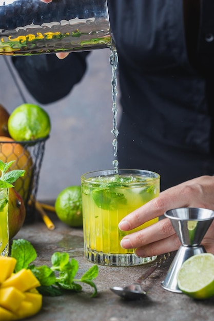 Coquetel de mojito de manga fresca com limão e hortelã em um copo