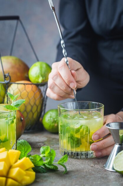 Coquetel de mojito de manga fresca com limão e hortelã em um copo