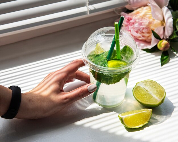 Coquetel de mojito em mãos femininas