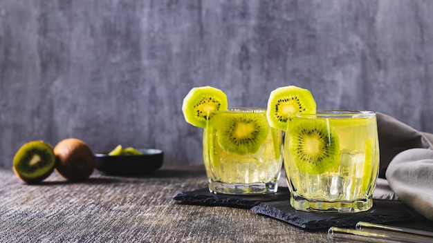 Foto coquetel de mojito frio de verão com kiwi em copos na bandeira da web da mesa