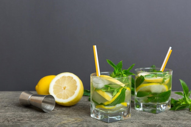 Coquetel de mojito Refrescante coquetel de mojito com limão e hortelã em um copo alto com um palito