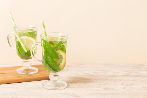 Coquetel de mojito Refrescante coquetel de mojito com limão e hortelã em um copo alto com um palito