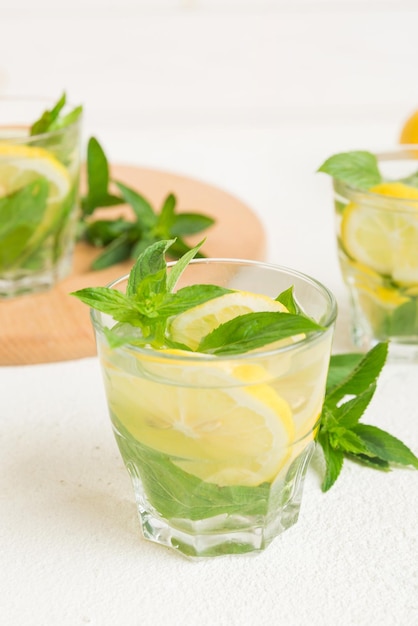 Coquetel de mojito Refrescante coquetel de mojito com limão e hortelã em um copo alto com um palito