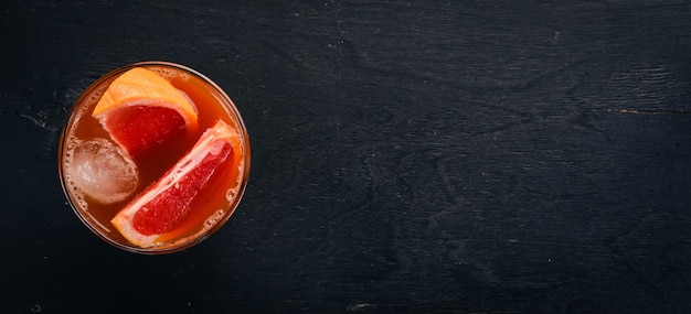 Coquetel de uísque e suco de toranja Em um fundo preto de madeira Vista superior Copie o espaço