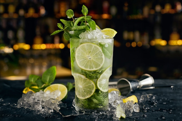 Coquetel Mojito, contra a superfície das garrafas, no bar, com atributos de bar