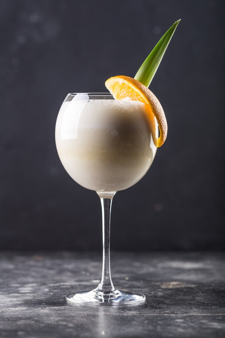 Coquetel refrescante à base de álcool pina colada em copo posicionado sobre a mesa