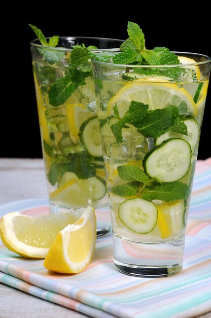 Coquetel refrescante de mojito de pepino com rodelas de limão e hortelã