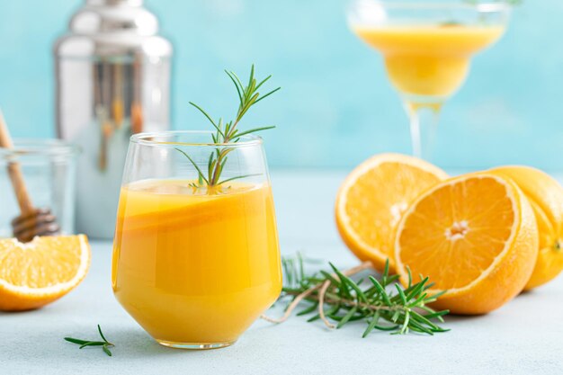 Coquetel refrescante de verão com mel e bourbon com alecrim e suco de laranja