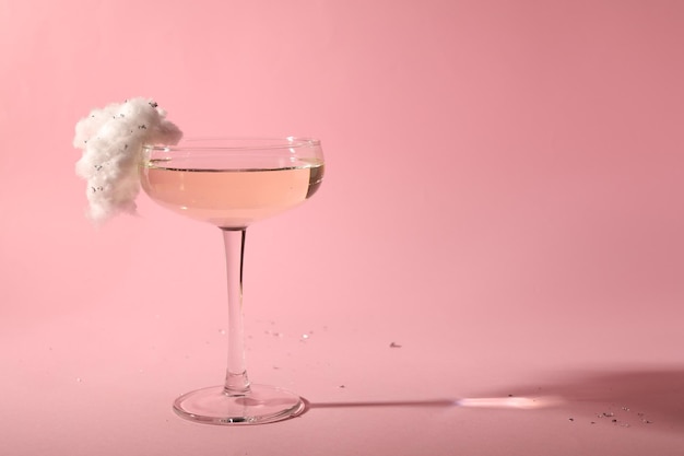 Coquetel saboroso em vidro decorado com algodão doce em fundo rosa espaço para texto