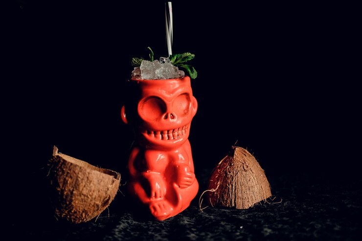 Foto coquetel tiki com coco e hortelã em superfície escura