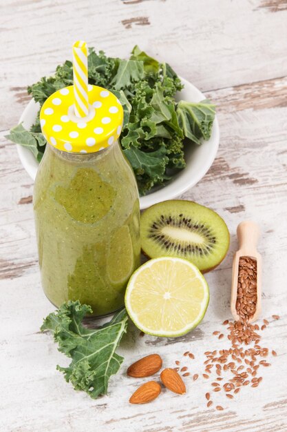 Foto coquetel verde recém-misturado de frutas, legumes e outros ingredientes conceito de dieta e nutrição saudável