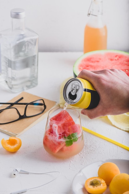 Coquetel vermelho com cubos de melancia congelados gin e refrigerante