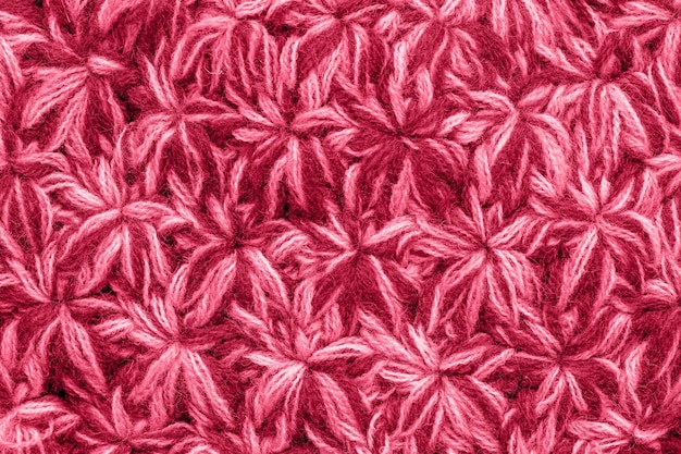 Foto cor da moda do ano 2023 textura do tecido de malha tonificado em viva cor magenta crochê de fios feitos à mão um padrão de asteriscos ou flocos de neve