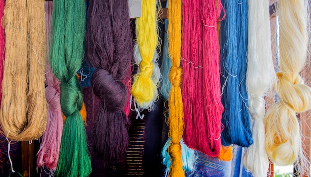 cor de tecelagem de seda artesanal hanking em rack de madeira.