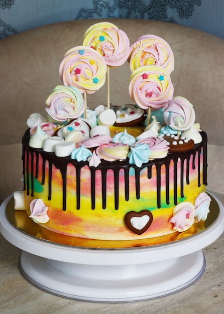 Cor do arco-íris do bolo infantil em um branco com merengue de madeira