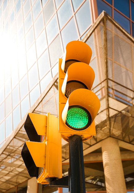 Cor verde no semáforo em frente ao prédio moderno