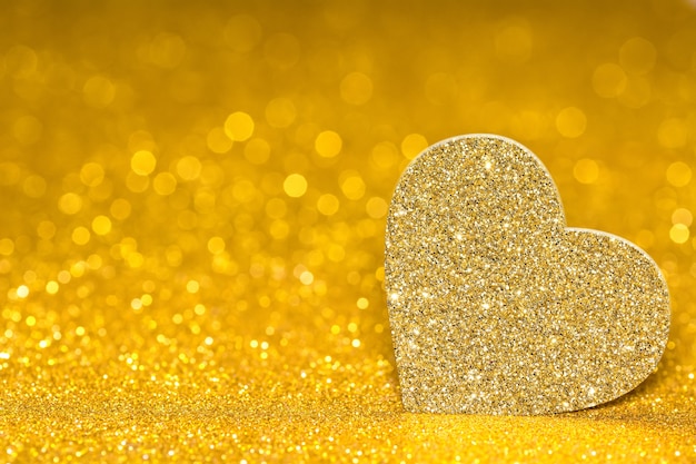 Coração brilhante sobre um fundo dourado radiante. Brilho de brilho com forma 3d.