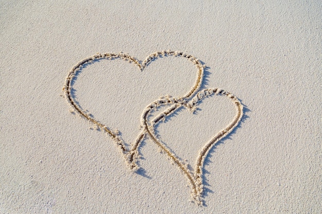 Coração closeup na areia da praia. Conceito de romance de amor, modelo de dia dos namorados