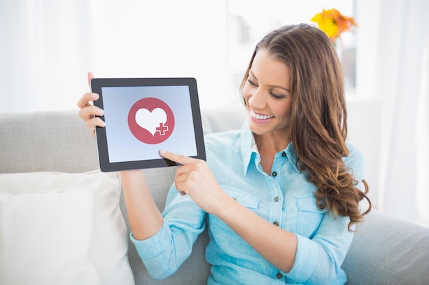 coração contra mulher sorridente mostrando a tela do tablet