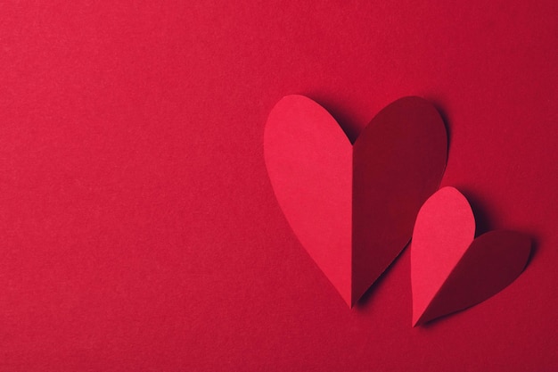 Coração de amor de papel vermelho em um fundo vermelho liso Fundo de romance de dia dos namorados