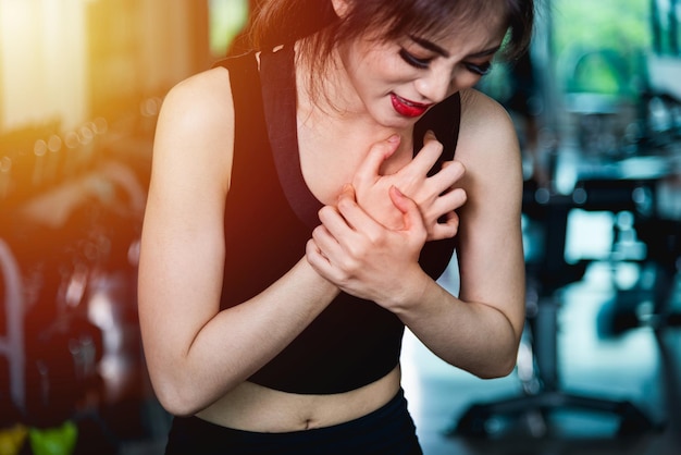 Coração de ataque de peito de dor de lesão de mulher após exercício de treinamento de treino no ginásio de fitness