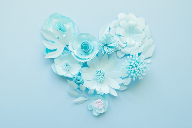 Coração de flores de papel azul no azul.