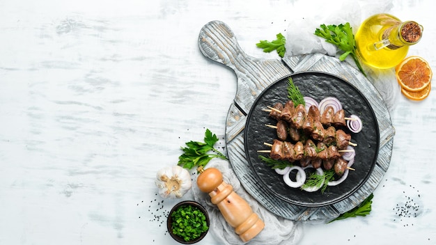 Coração de frango assado em espetos em um prato preto Carne de frango Vista superior Espaço livre para o seu texto