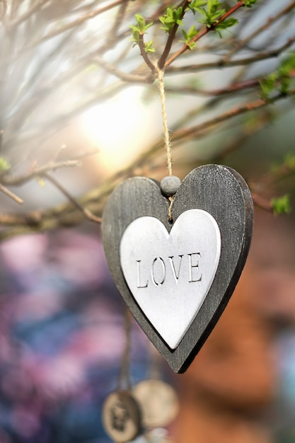 Coração de madeira com quatro letras esculpidas no fundo desfocado. símbolo de amor. conceito de dia dos namorados