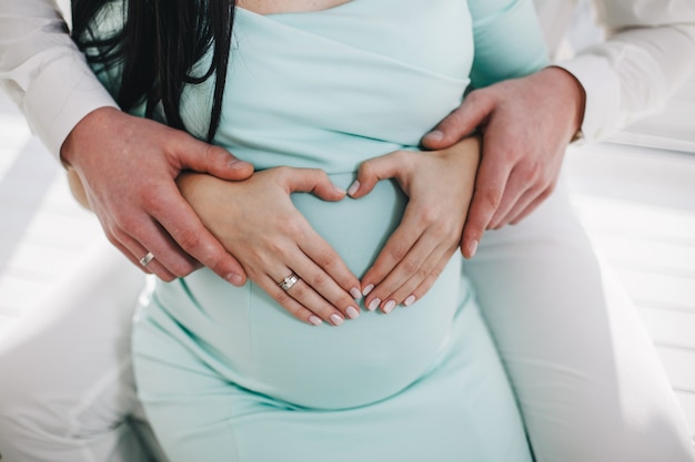 Foto coração de mãos no estômago de uma menina grávida