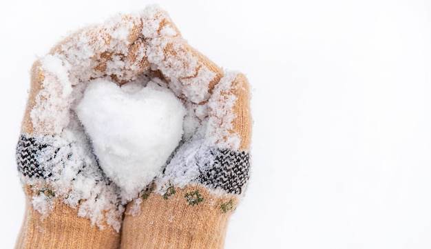 Coração de neve em foco seletivo de mãos