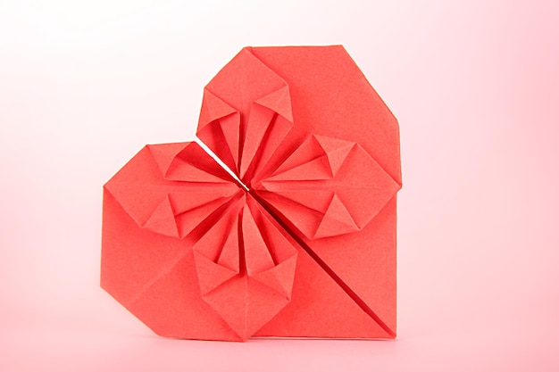 Coração de papel origami em fundo rosa