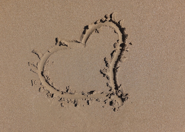 Coração desenhado na areia molhada, close up