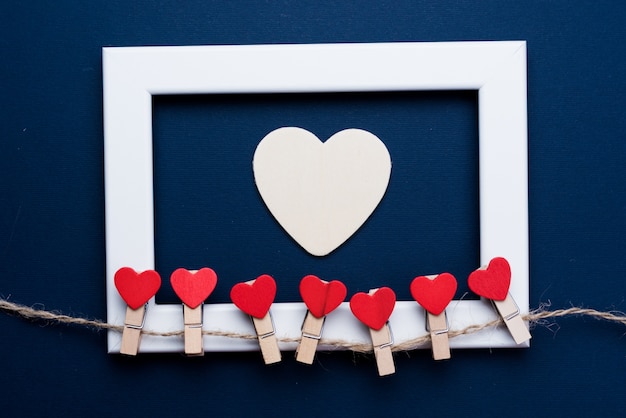 Foto coração e quadro no fundo azul do conceito do dia do valentim e conceito do amor. copie espaço para texto.