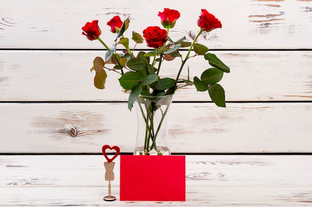 Coração em pé e rosas cumprimentando coração de papel e flores enviam votos de felicidades, o amor está por toda parte