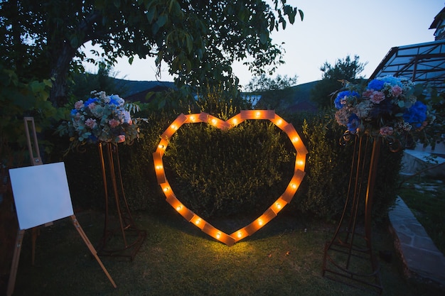 Coração feito à mão iluminado por lâmpadas