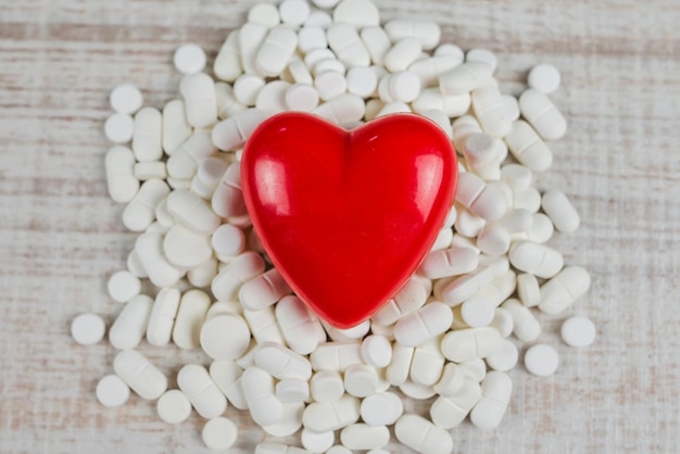 Coração vermelho e pílulas brancas O conceito de doença cardiovascular
