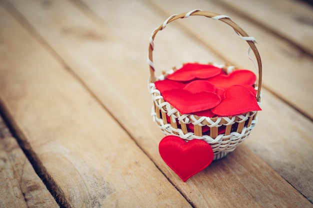 Coração vermelho na cesta na mesa de madeira para o dia dos namorados e conceito de amor