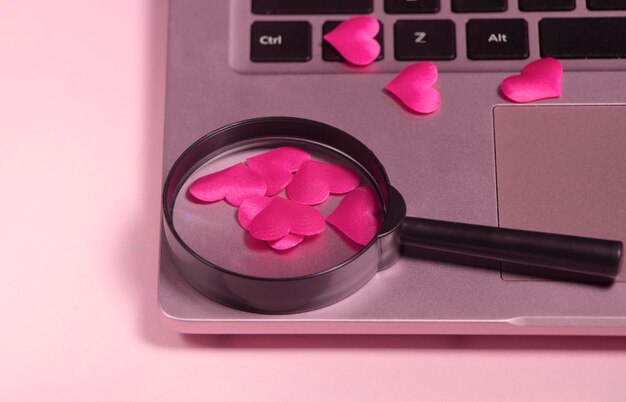 Foto coração vermelho no teclado do computador, lupa com alça