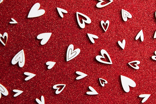 Corações brancas em uma superfície de glitter vermelho
