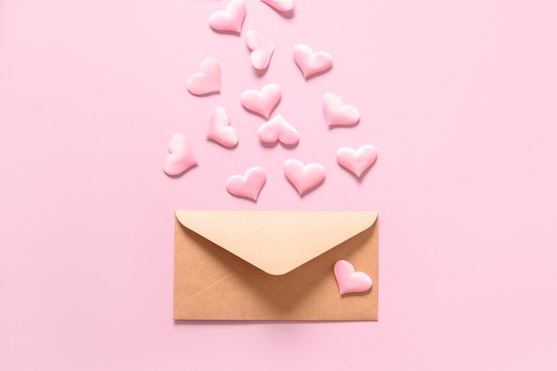 Corações de amor rosa de envelope em fundo rosa. cartão de dia dos namorados com espaço de cópia.