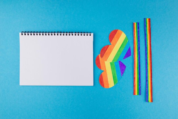 Corações de arco-íris do símbolo LGBT com um bloco de notas em branco sobre direitos de fundo azul e espaço de cópia de igualdade de gênero Lugar para texto